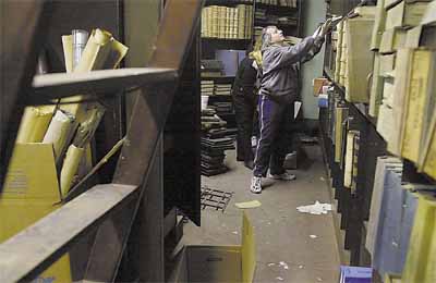 Maria Stabile, from the city and town clerk's office, sorts through documents in the basement of Old Town Hall